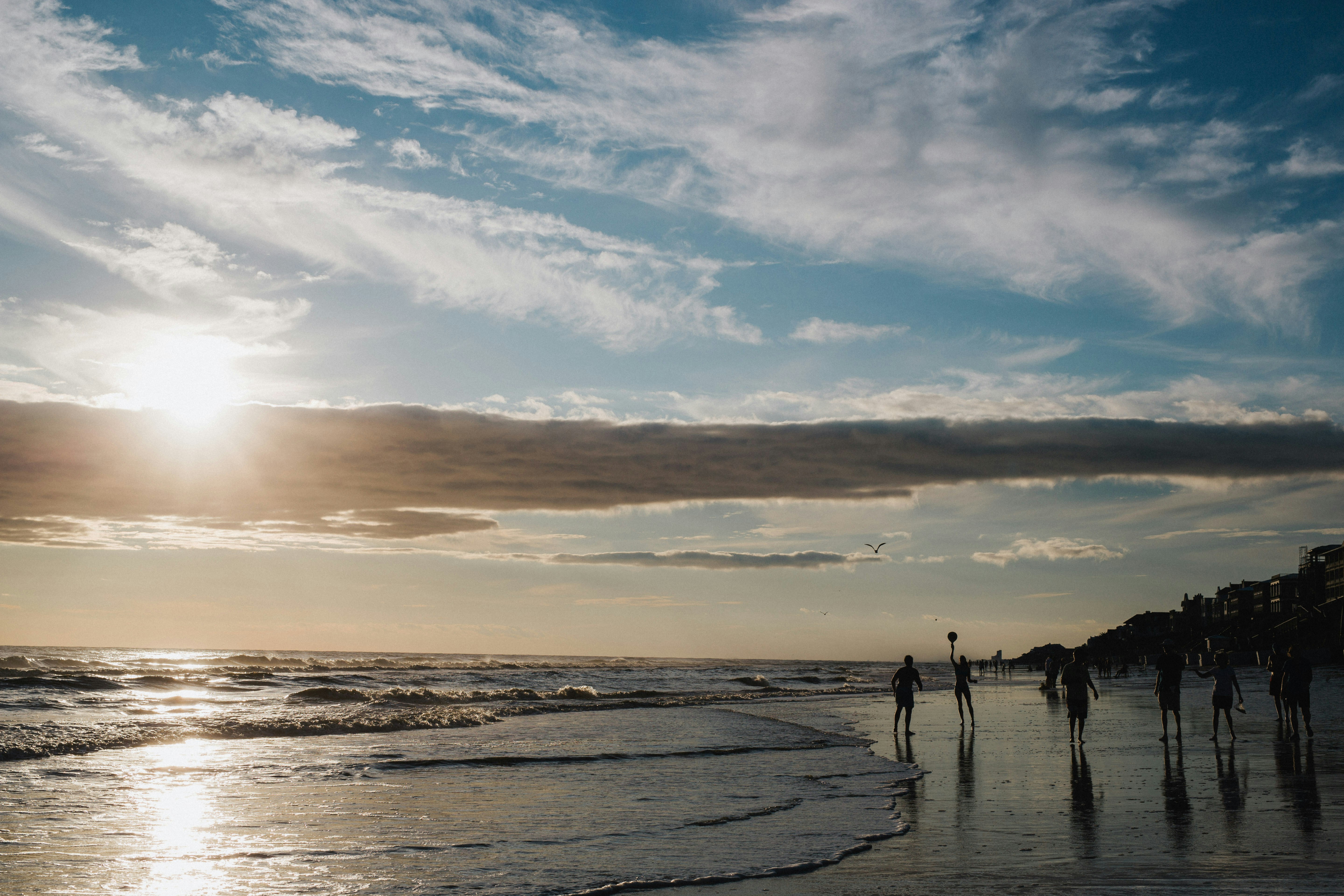 people walking on beach during sunset